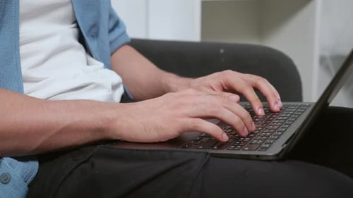 Close up hands typing on laptop keyboard, remote work freelancer in home office.