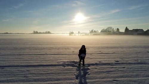 Little boy playing in the snow on big field