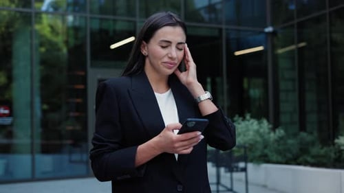 Woman Using Cellphone Outdoors in Urban Setting