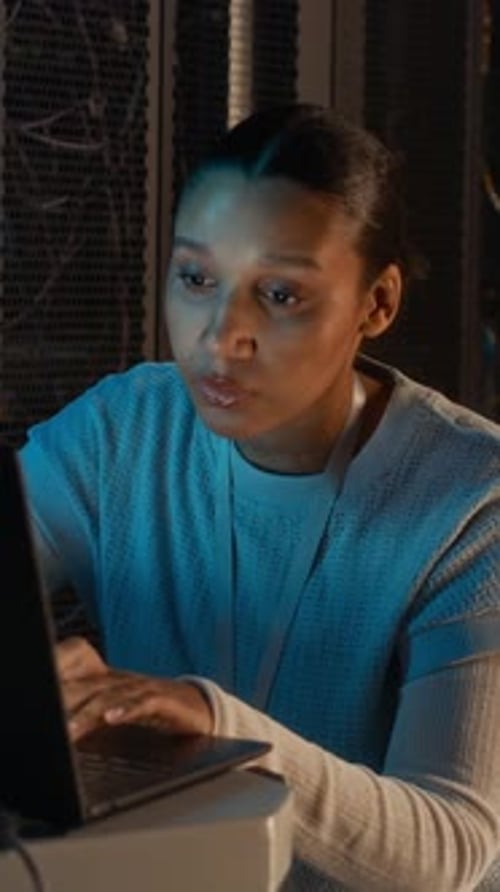 Female Engineer Programming on Computer in Data Center