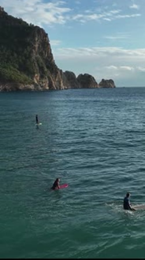 Vertical Video Captivating Aerial Perspective Surfers Catching Waves in Alanya Turkey
