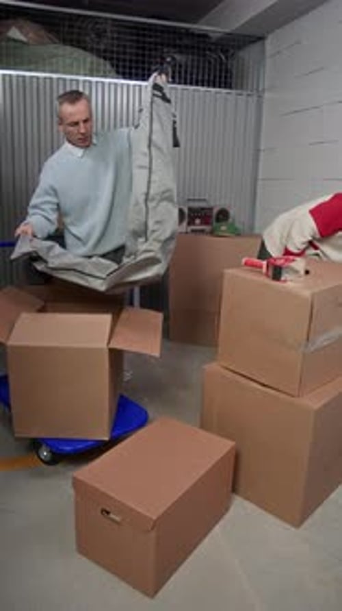 Un père et son fils déballent leur veste d'hiver et discutent de leur veste d'hiver dans une unité de rangement