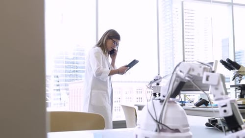 Una ingeniera habla por teléfono inteligente en un laboratorio de tecnología en el trabajo