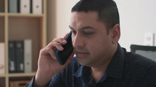 Man Talking on Smartphone in Office Setting