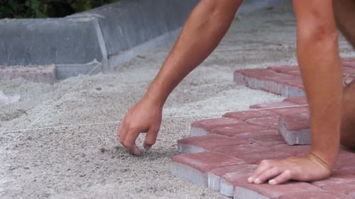 Worker Laying Stone Paving Slab