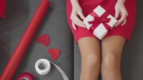 Woman Holds Birthday Gift While Lying on Sofa