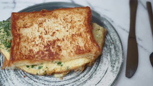 Delicious Toasted Egg Sandwich on Plate with Silverware