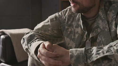 Young Military Veteran Rubbing Knuckles when Talking during Therapy Session