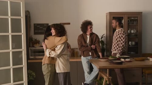 Friends Talking and Hugging in Kitchen