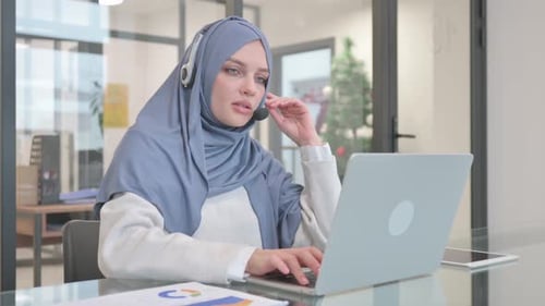 Woman in Hijab with Headset Talking Online in Call Center