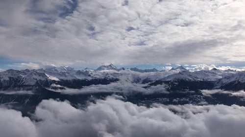 Majestic Aerial View of Snowy Mountains Above the Clouds