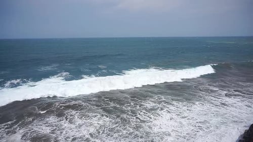 beautiful stretch of beach with blue sea water with big waves during the day