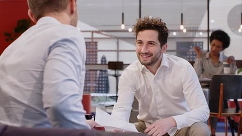 Businessmen sitting in office discussing document