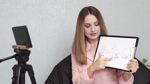 A math teacher conducts an online lesson with high school students via a tablet.