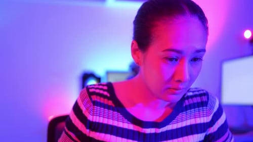 Woman Eating Noodles While Looking at Laptop