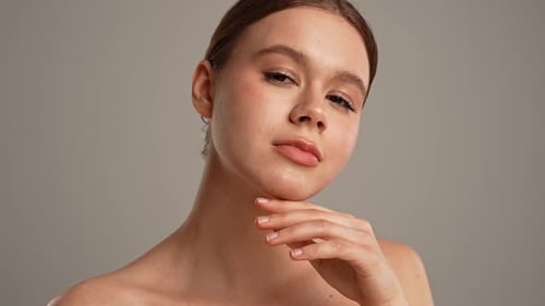 Young Woman Posing at Camera Playfully Smiling Touching Smooth Skin Close Shot Isolated on White