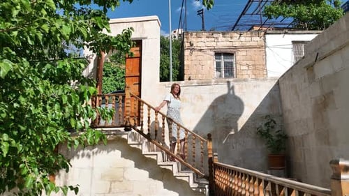 Woman Walking Down Stone Stairs in Urban Setting