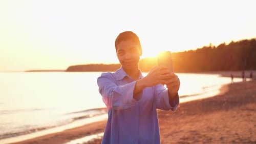 Young Adult Smiling on Beach at Sunset