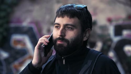 Handy, Kommunikation - junger Mann spricht auf dem Handy über die Arbeit