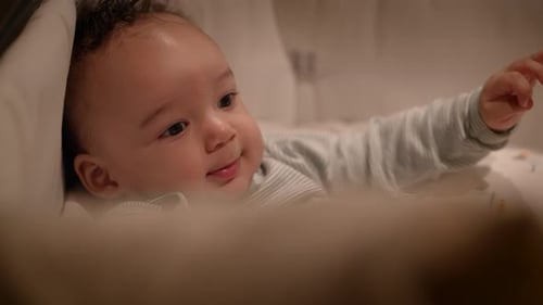 Sweet Infant Smiling in Crib at Home