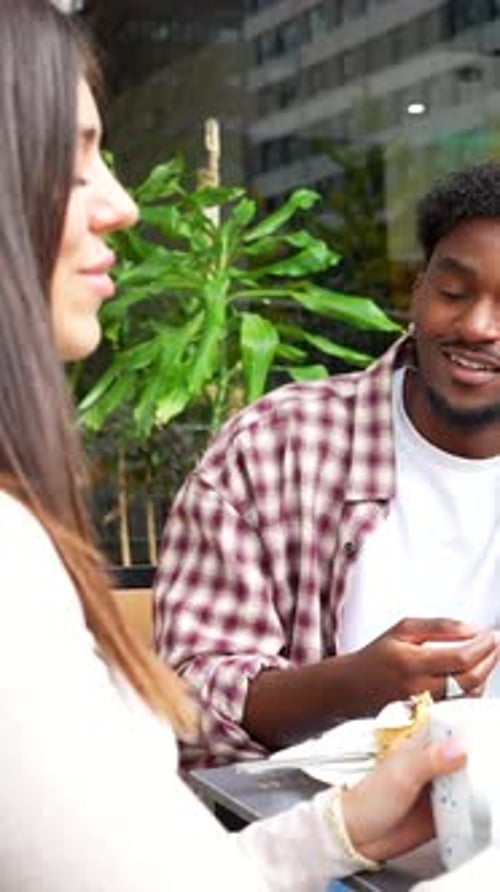 Diverse couple enjoying a conversation at an outdoor cafe