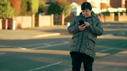 Woman Using Smartphone Standing Near Residential Street Old Female Scrolling Screen on Mobile Device