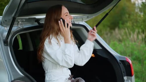 Woman Talks on Mobile Phone Near Car