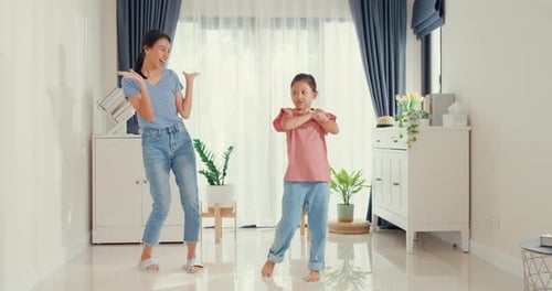 Mother and Daughter Dancing Together in the Living Room