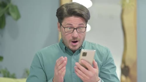 Man Expresses Excitement While Using Smartphone