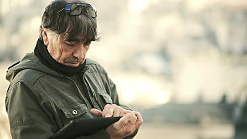 Adult Uses Tablet Outdoors in Daylight