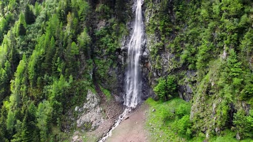 Zoom out footage of a beautiful waterfall and trees on a mountain side