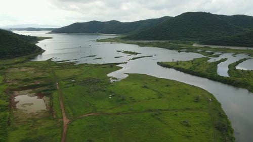 Aerial View Unveiling Grasslands and a Meandering River in Rural Areas