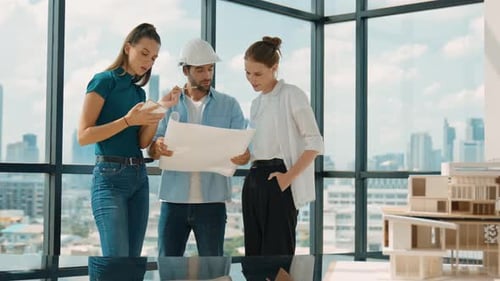 Architects and Designers Reviewing Blueprints in Modern Office