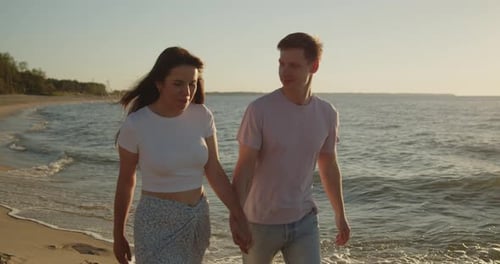 Young Loving Couple Enjoying Relaxing Sunset Walk on the Beach