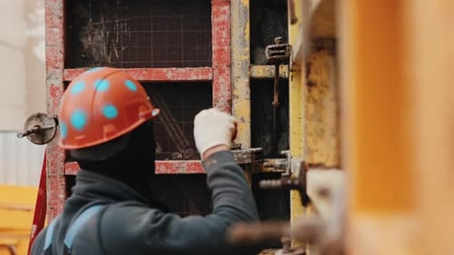 Worker Inserting Formwork Tie Rod Into Wall Formwork System