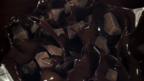 Pieces of Chocolate Fall Into the Melted Chocolate Filmed on a Highspeed Camera at 1000 Fps