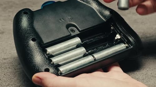 Das Hinzufügen von Silberbatterien (AA und AAA) in Konsolennahaufnahmen ist bei tragbaren Elektronisch Geräten üblich.