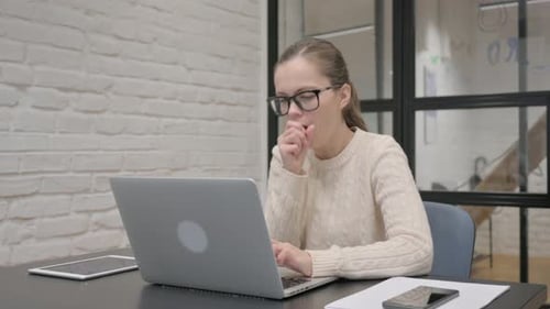 Woman Coughing While Working at Her Laptop