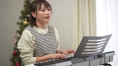 Woman Plays and Sings Piano at Christmas Time