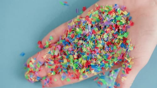 Hand Holding Colorful Confetti in a Close Up Shot