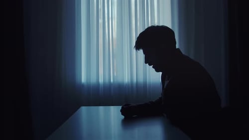 Silhouette sombre d'un homme inhalant un aérosol pour asthme