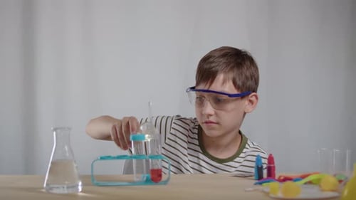 Boy Doing Science Experiment With Beakers and Test Tubes