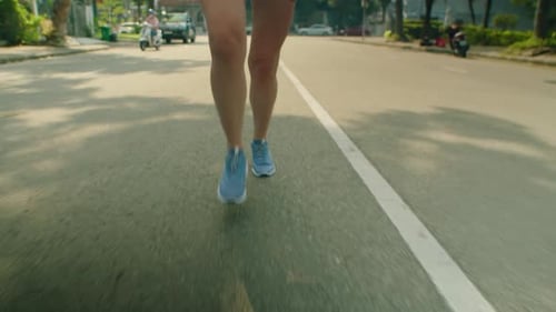 Woman Jogging along City Street on Sunny Morning