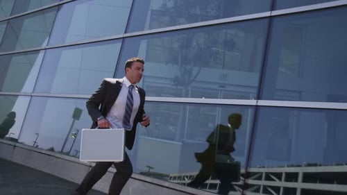 Business Man Running With Briefcase by Modern Building