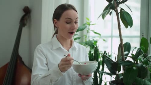 Woman Eating Salad in Bright Indoor Setting