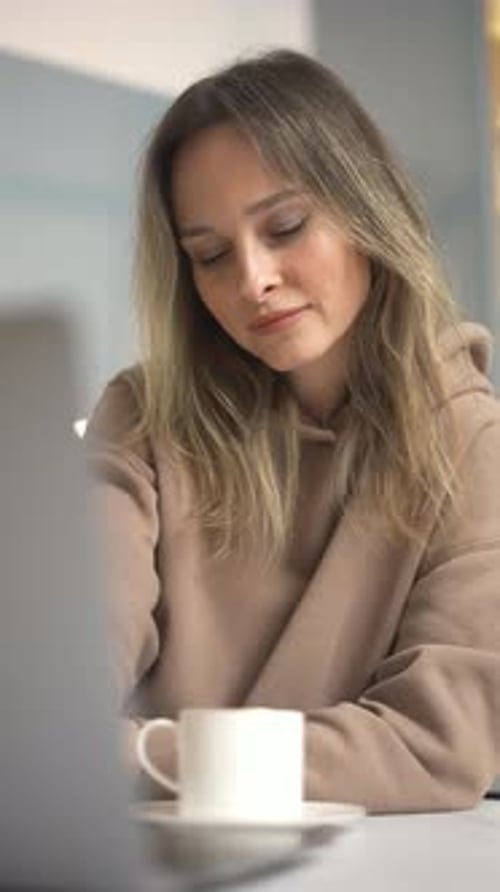 Woman Working on Laptop and Drinking Coffee