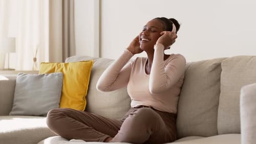 Woman Listens to Music on Headphones at Home