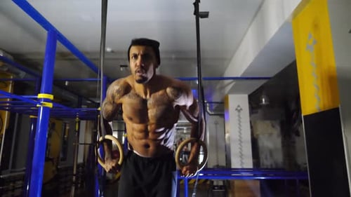 Muscular Afro American Sportsman Doing Push Ups on Gymnastic Rings at Gym Strong African Athlete