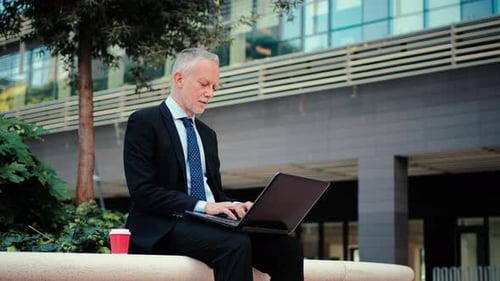 Mature Man Working on Laptop Outdoors