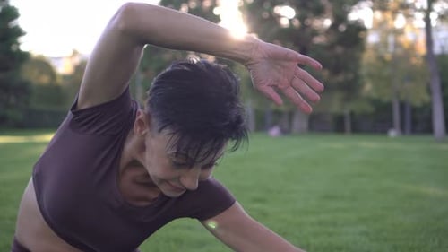 Woman Stretching in Park on Sunny Day
